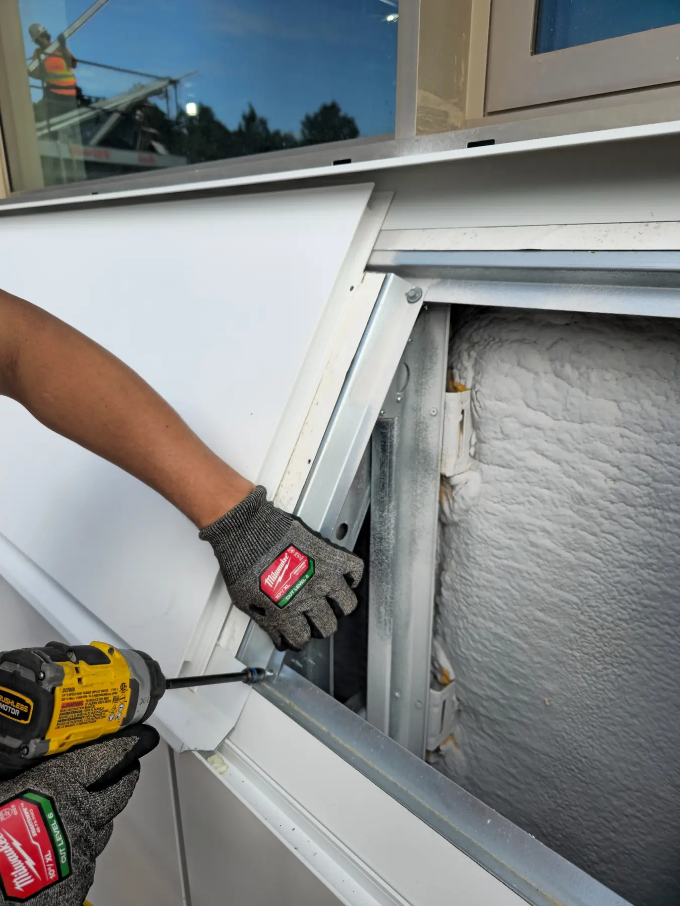 Pose de panneaux de revêtement métallique sur un mur extérieur
