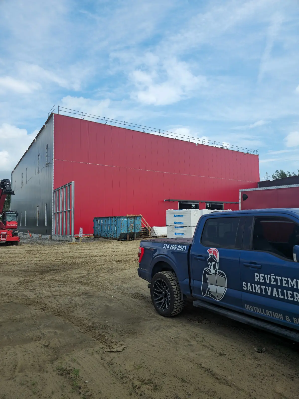Façade du Chapiteau Grandchamp avec revêtement métallique rouge et camion de Revêtement Saintvalier Montréal